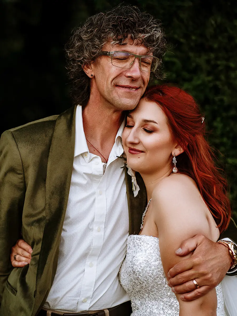 Bride with red hair resting her head on her groom's shoulder, both with eyes closed in a quiet tender moment — documentary wedding photography by Gary Phillip