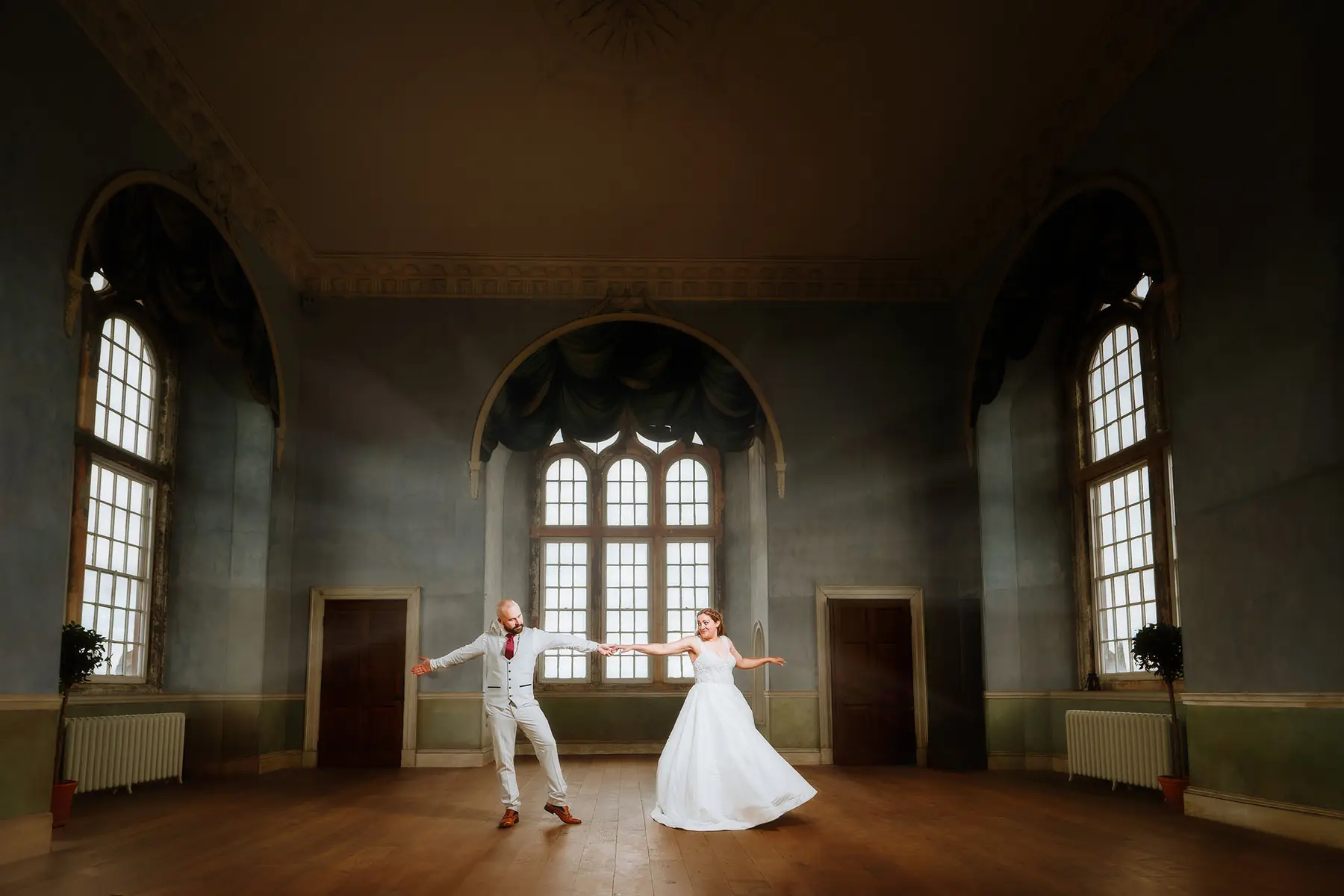 bride and groom dancing in the prospect room at wollaton hall, in beautiful light — documentary wedding photography by Gary Phillip
