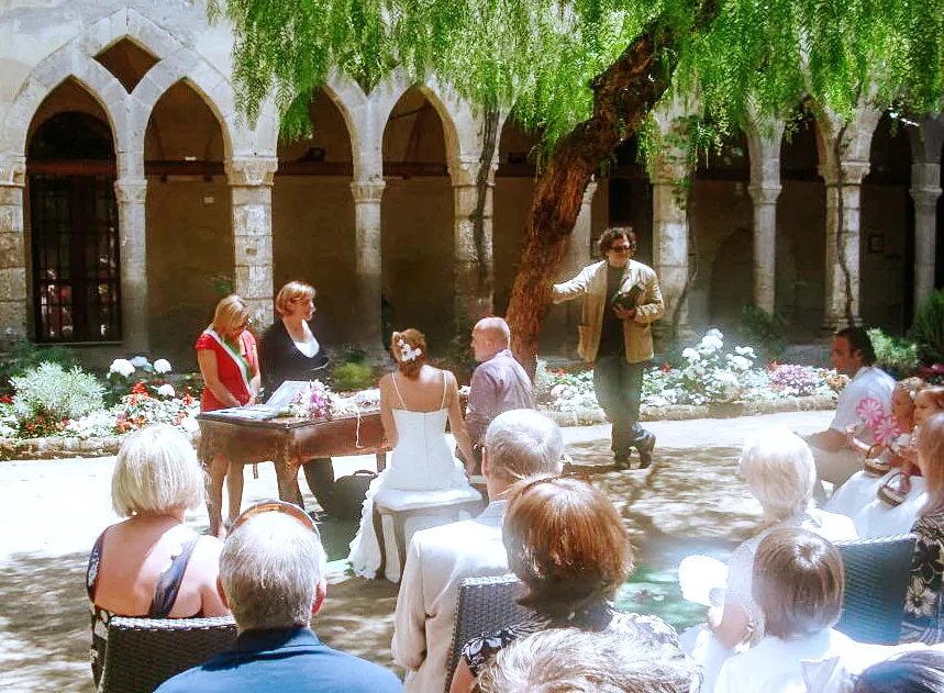 Gary and Amanda's wedding in Positano, 2008 — a guest photograph showing the couple at the ceremony while their photographer leans against a tree not watching