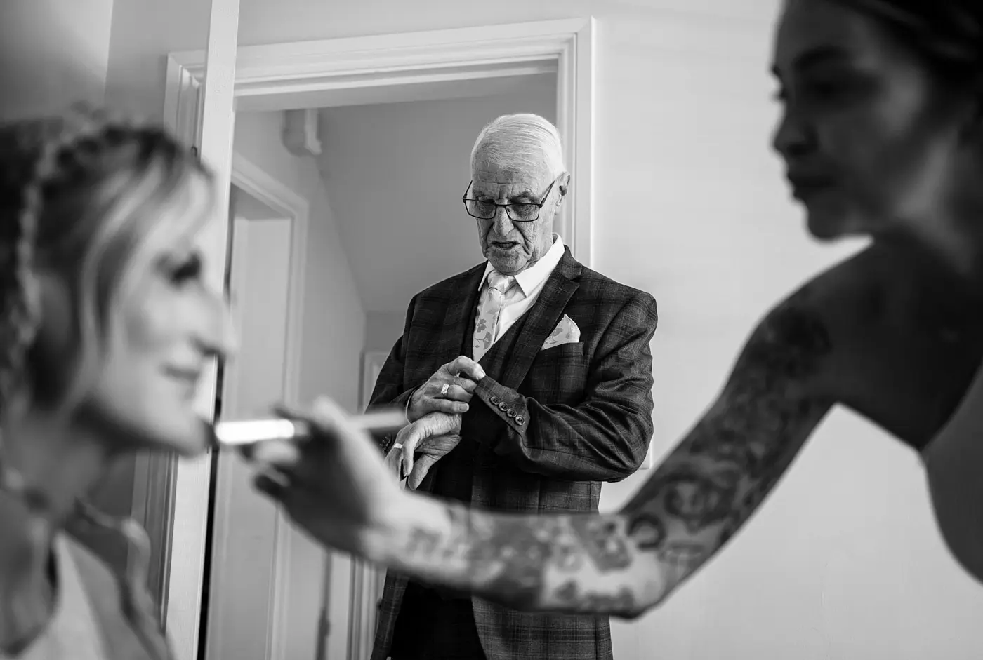 Father of the bride checking his watch as Amy takes her time getting ready on her wedding morning at Doddington Hall, Lincolnshire