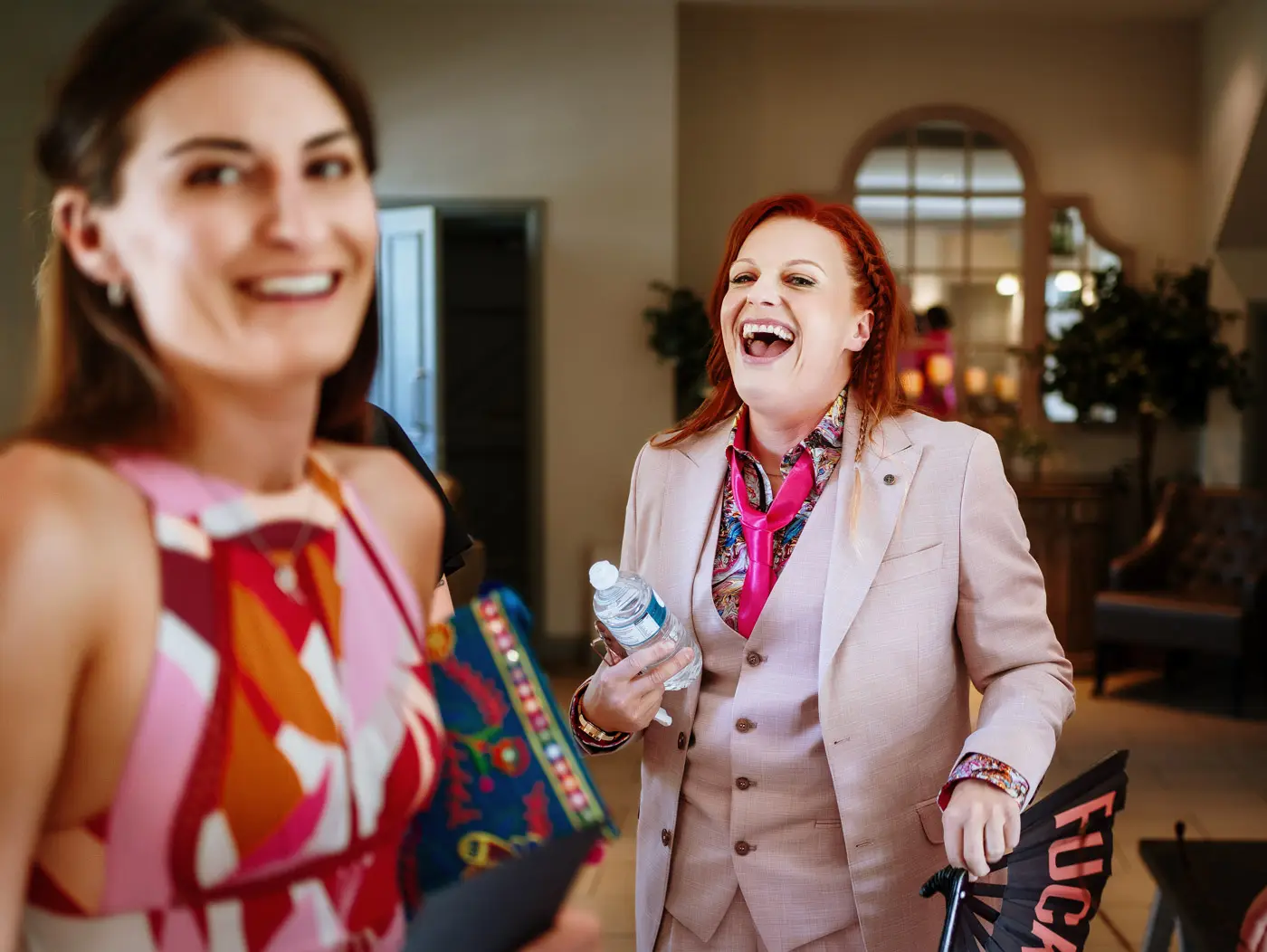 Abby arriving laughing in the coach house foyer at Doddington Hall, Lincolnshire on her wedding day