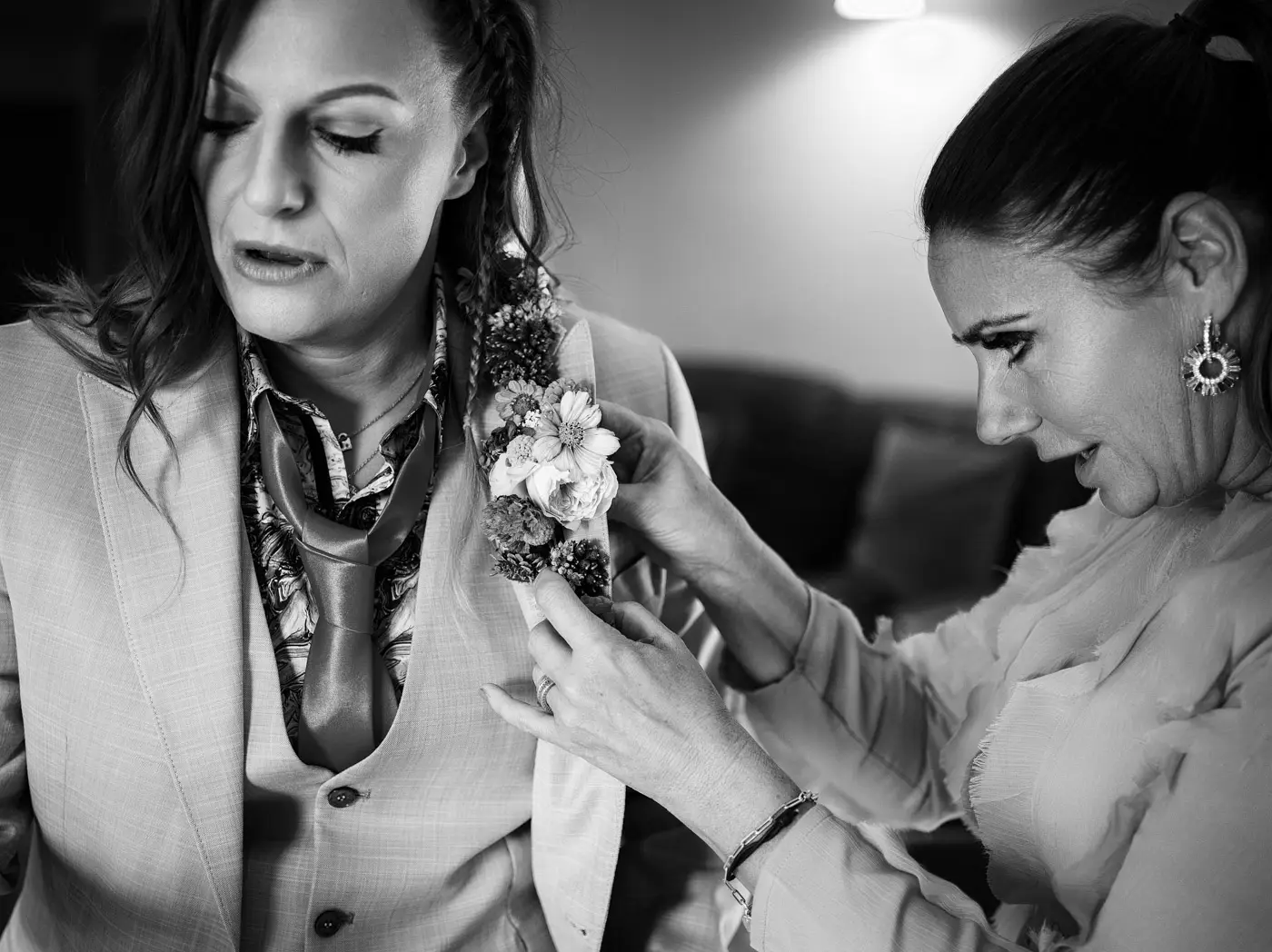 Abby having her buttonhole flower fitted before the wedding ceremony at Doddington Hall, Lincolnshire