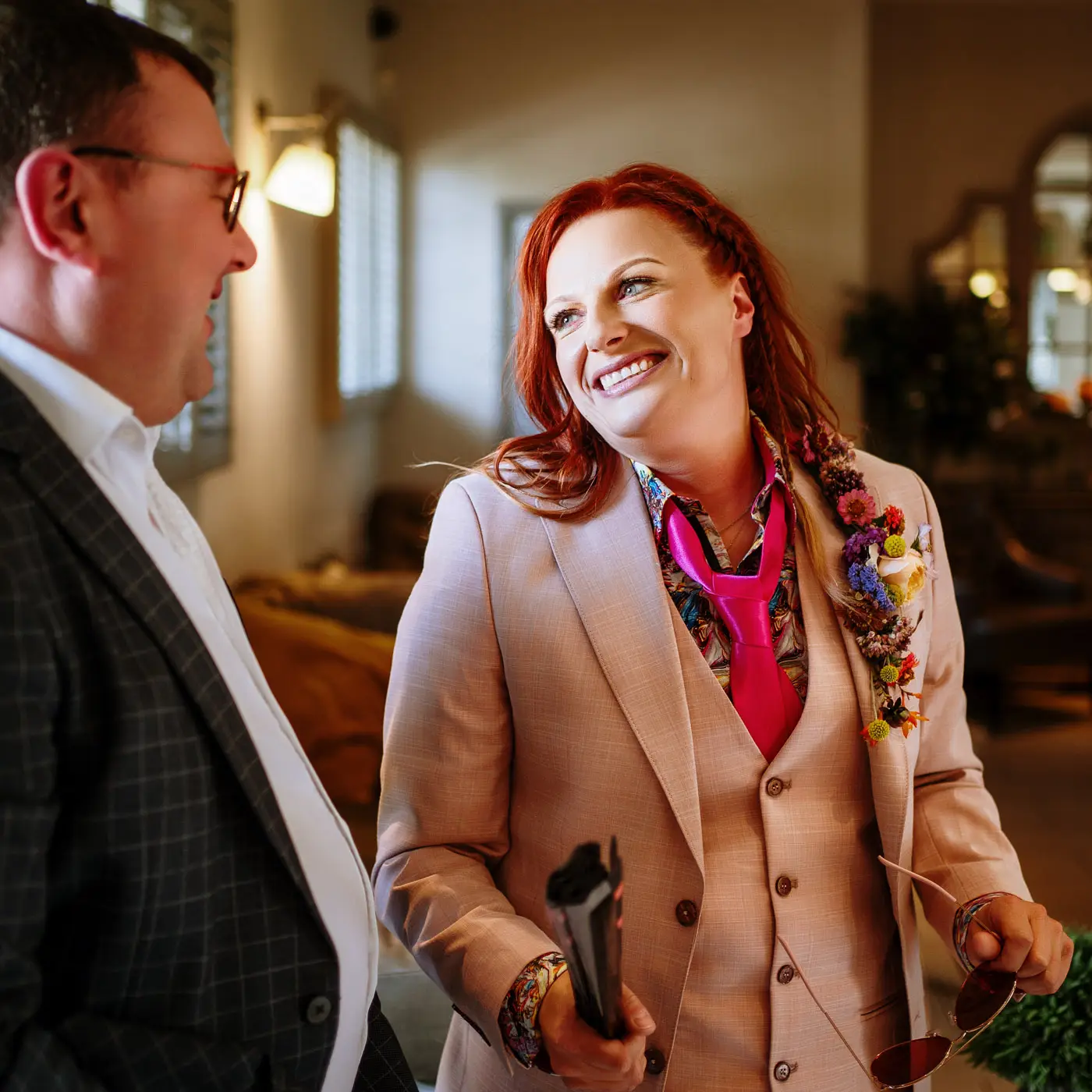 Abby laughing with a guest as they make their way through to the garden at Doddington Hall, Lincolnshire ahead of the ceremony