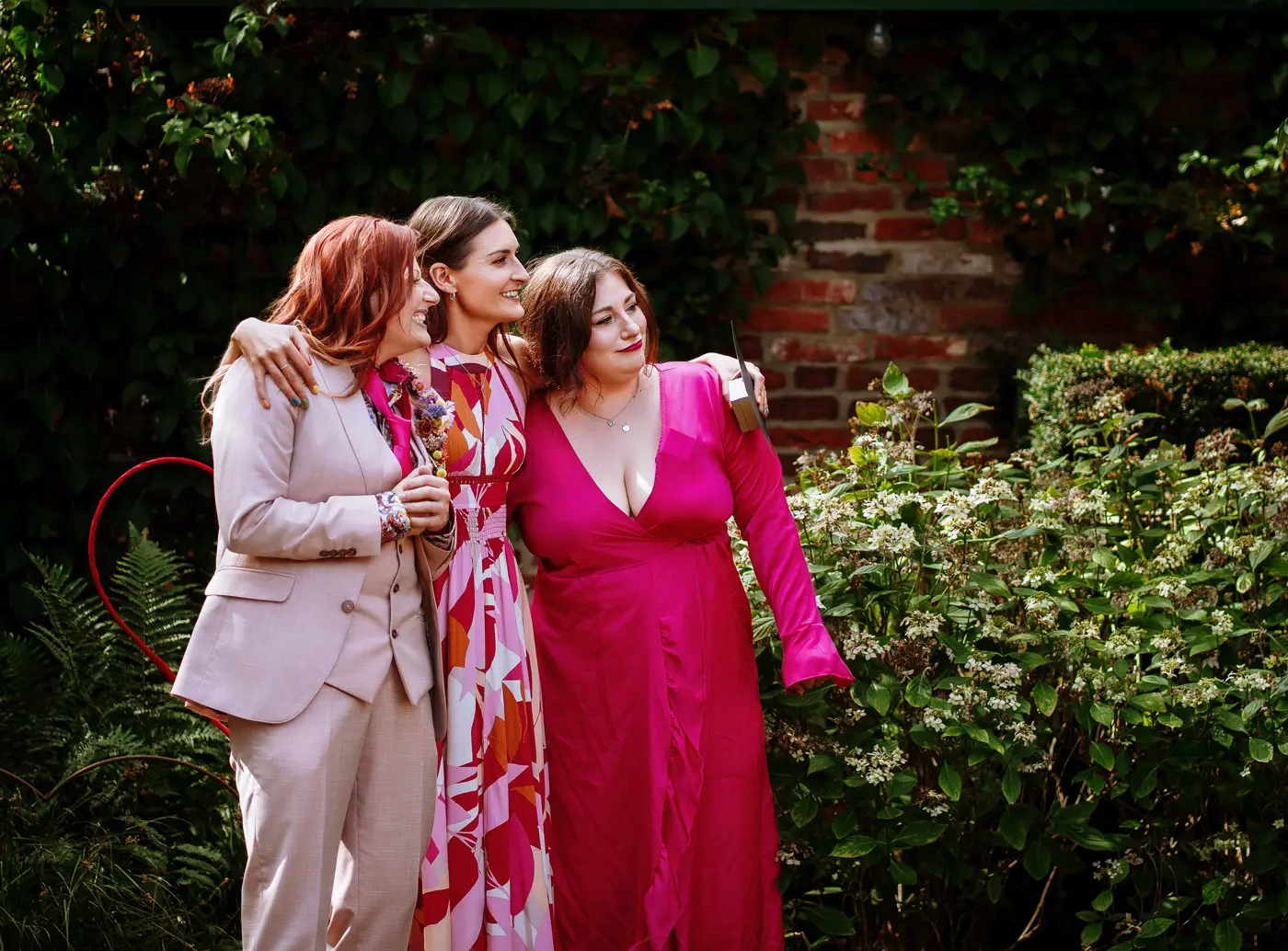 Abby and her two best women waiting at the front with big smiles as a guest takes their photograph at Doddington Hall, Lincolnshire