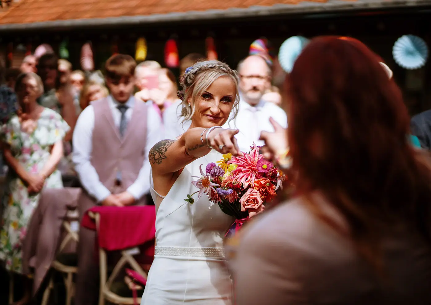 Amy and Abby pointing at each other with delight at the front of the ceremony room at Doddington Hall, Lincolnshire