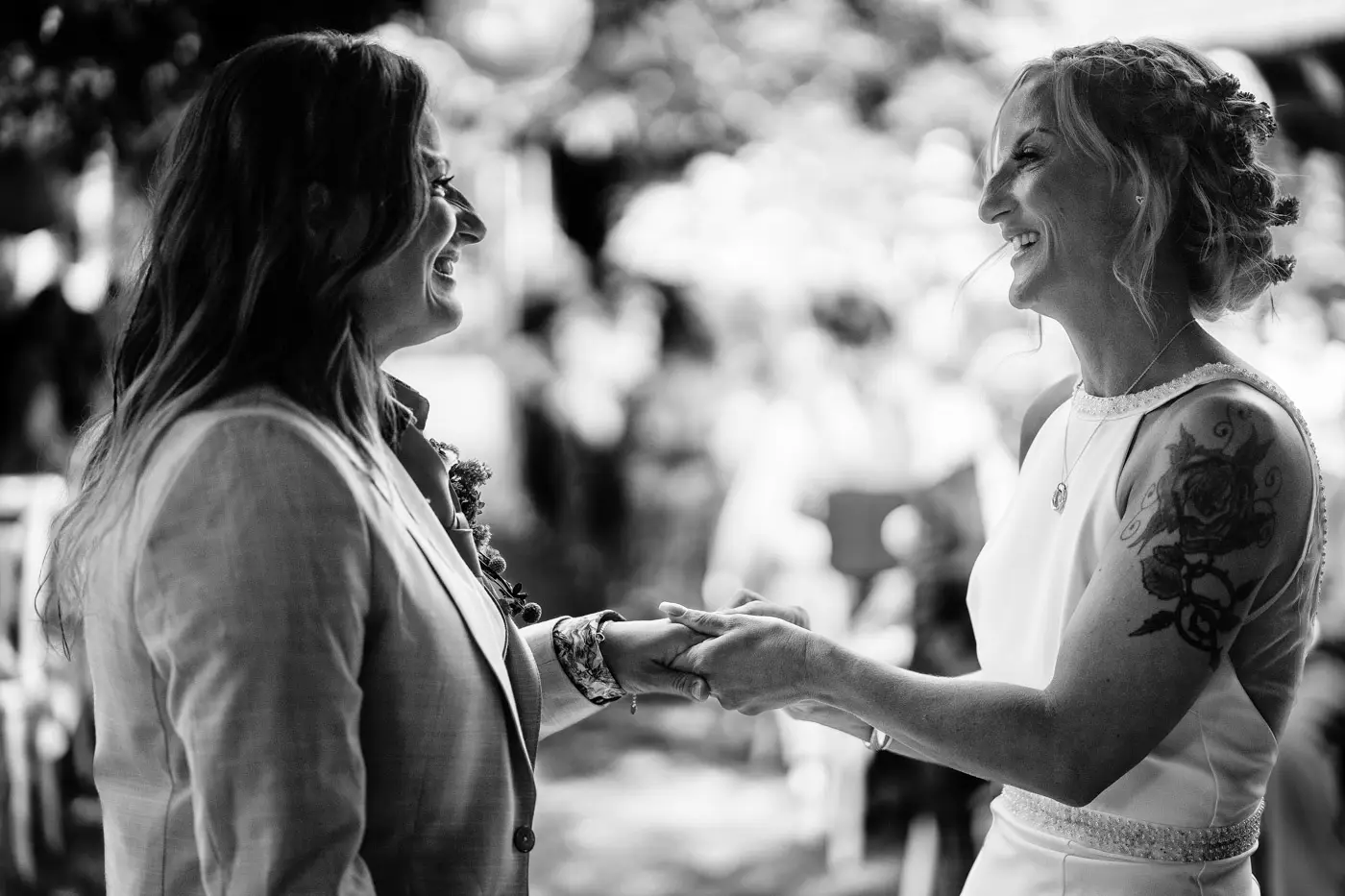 Close three quarter shot of Amy and Abby holding hands during their wedding ceremony at Doddington Hall, Lincolnshire