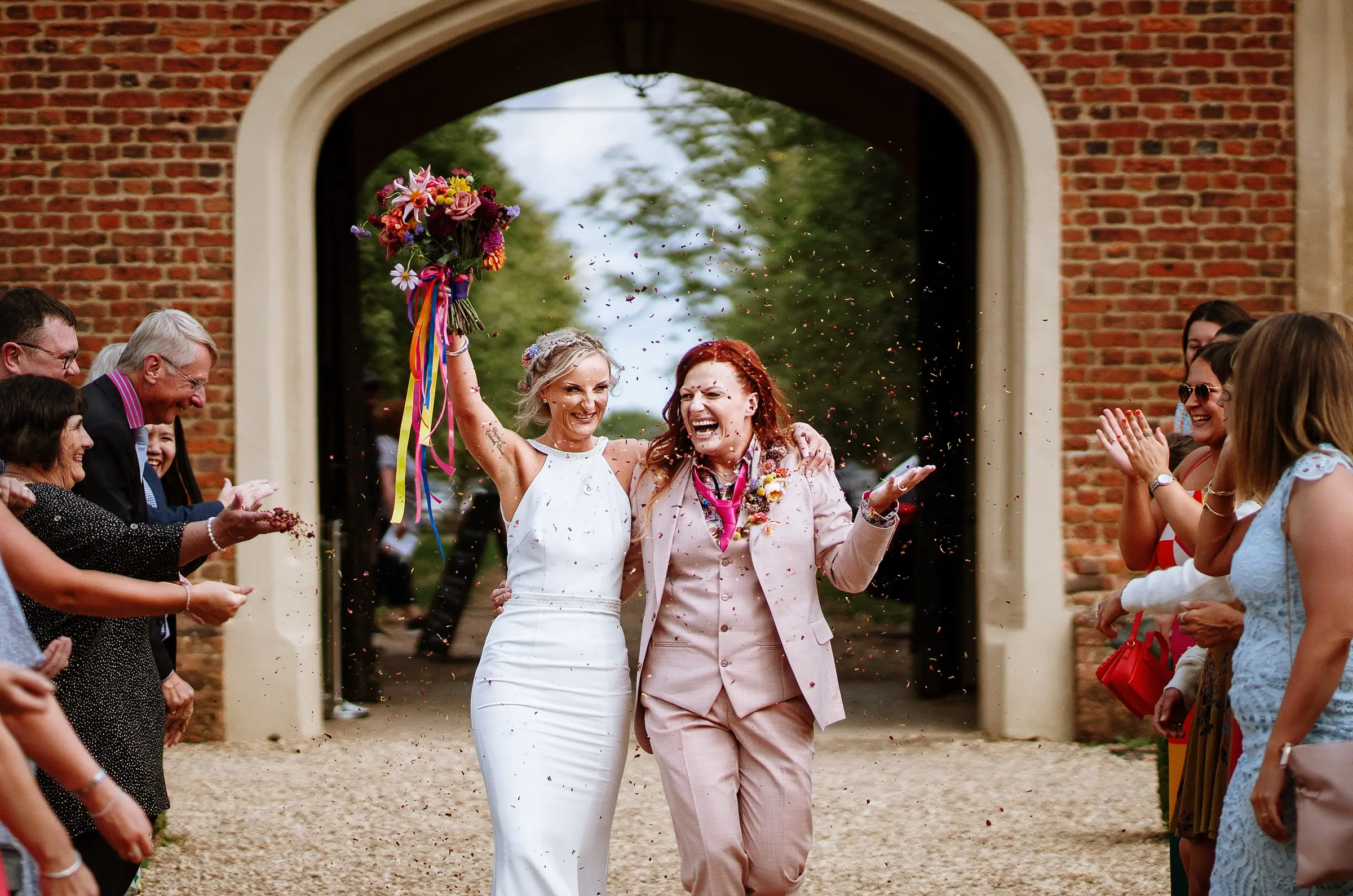 Amy and Abby starting their confetti walk as a married couple outside Doddington Hall, Lincolnshire, documentary wedding photography by Gary Phillip