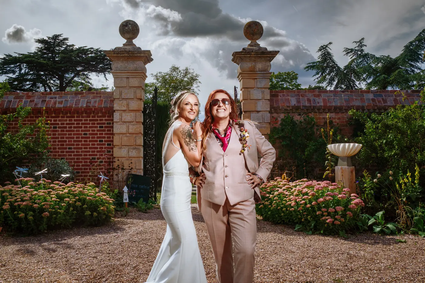 Portrait of Amy and Abby looking proud together in the gardens of Doddington Hall, Lincolnshire on their wedding day