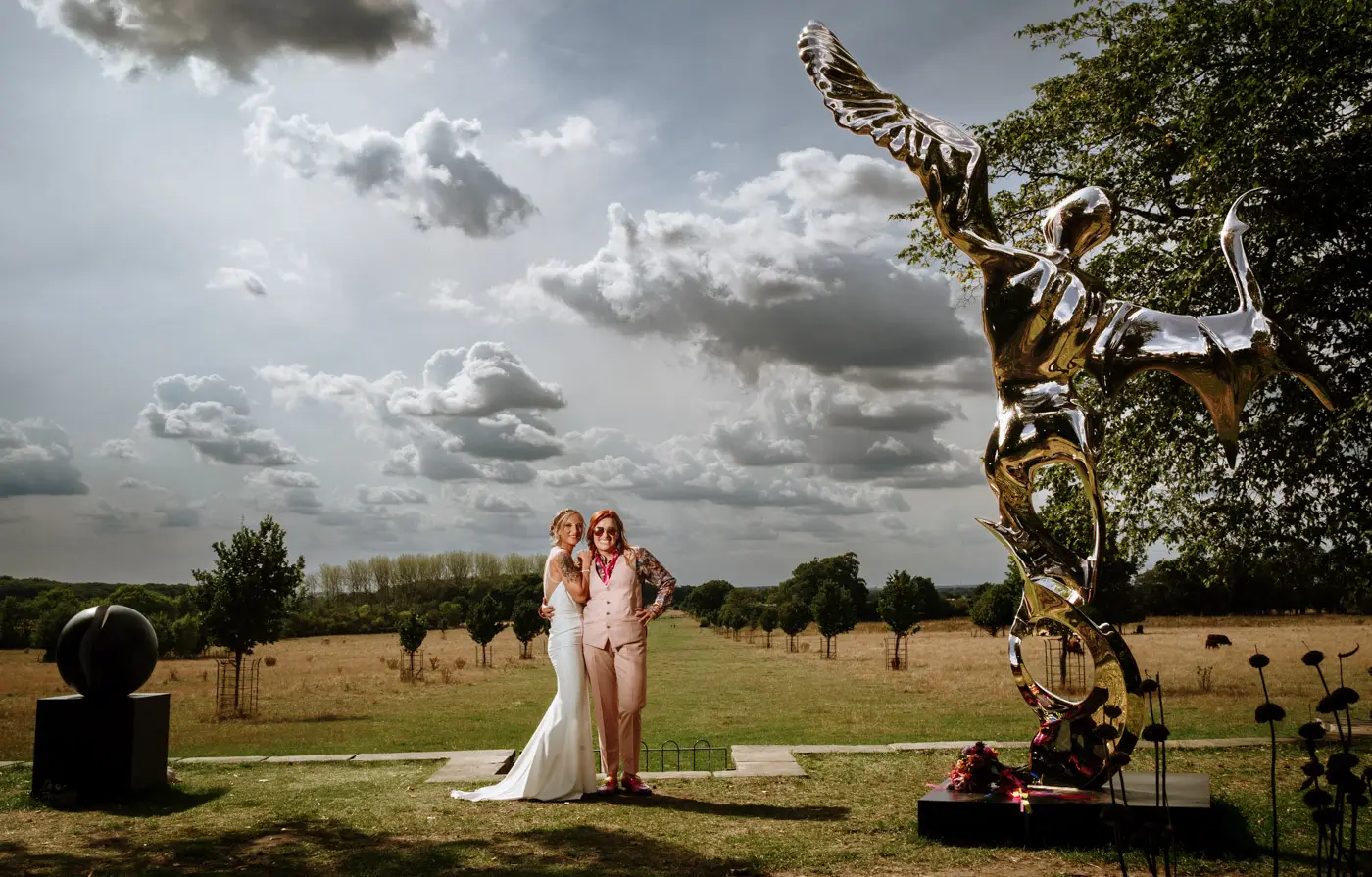 Amy and Abby portrait next to an amazing chrome angel sculpture at Doddington Hall with dramatic skies behind them, Lincolnshire