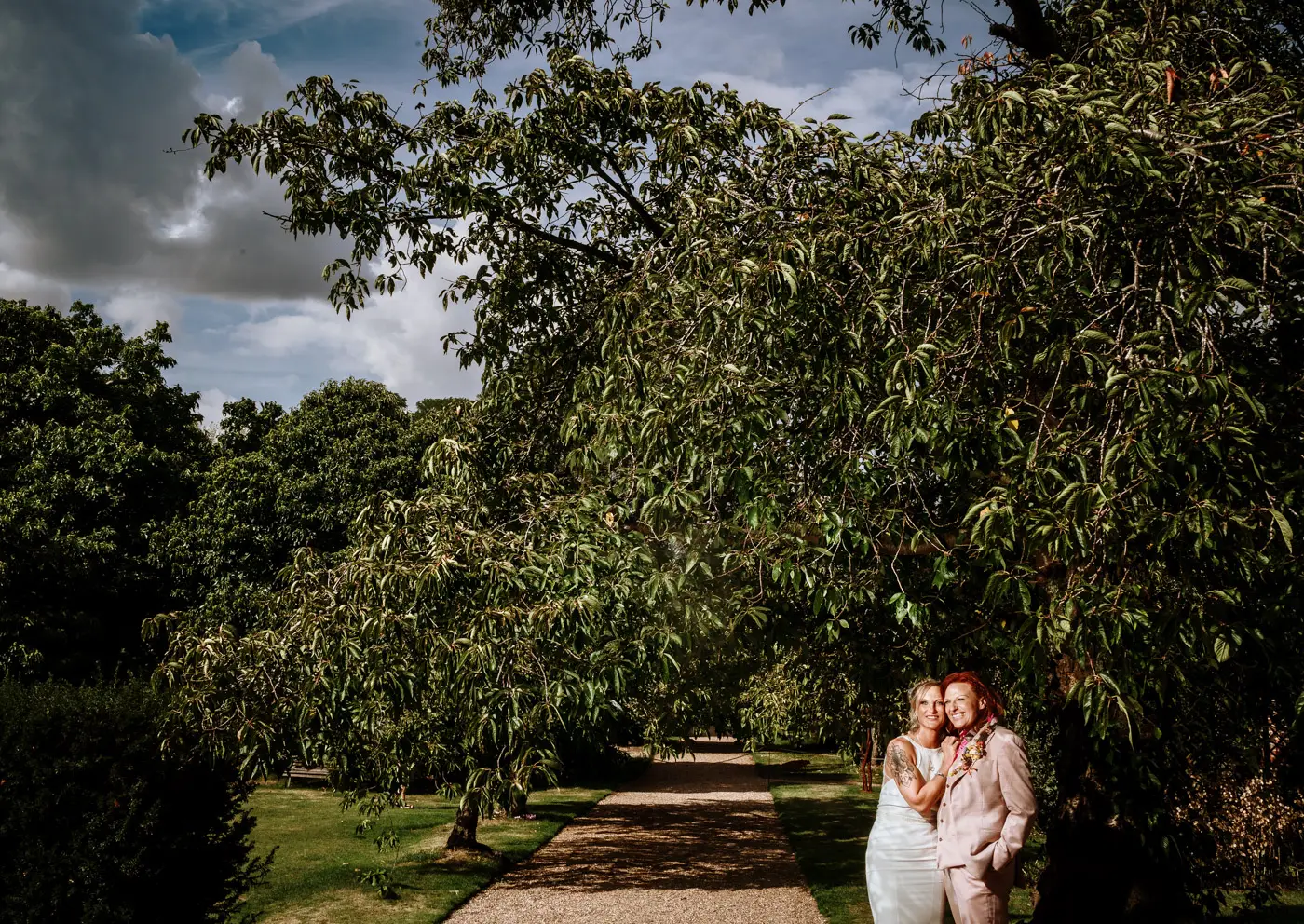 Amy and Abby sharing a portrait moment under a tree in the grounds of Doddington Hall, Lincolnshire on their wedding day