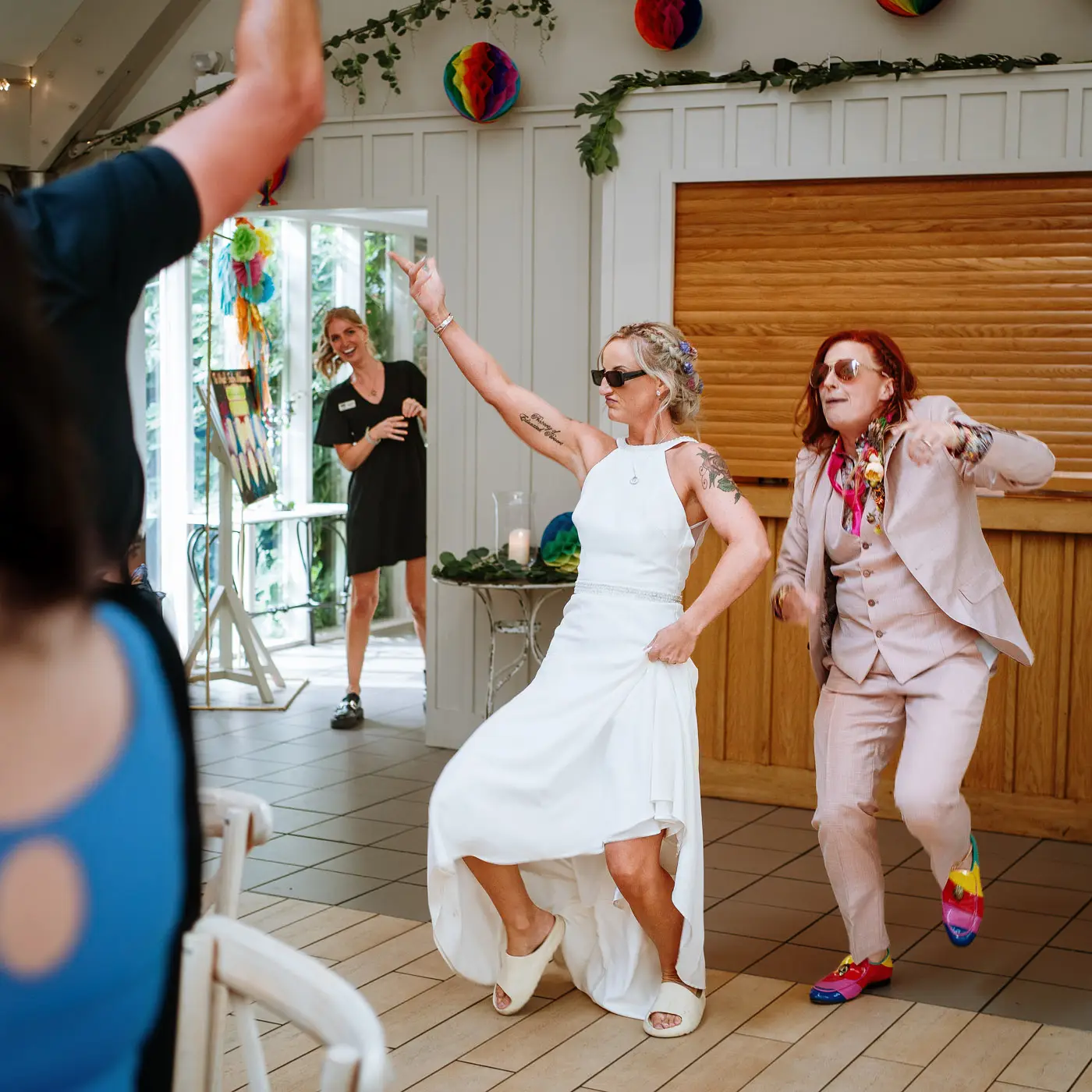 Amy and Abby pausing their entrance dance to point at their guests in the coach house at Doddington Hall, Lincolnshire