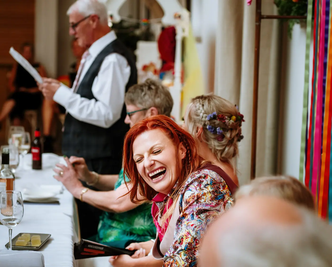 Abby laughing at the father of the bride's speech during the wedding breakfast at Doddington Hall, Lincolnshire