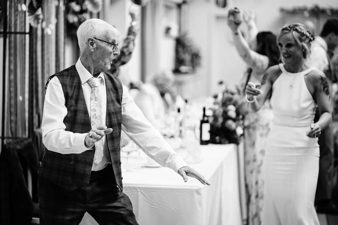 Dad dancing at the top table during Amy and Abby's wedding reception at Doddington Hall, Lincolnshire, a joyful candid moment by Gary Phillip