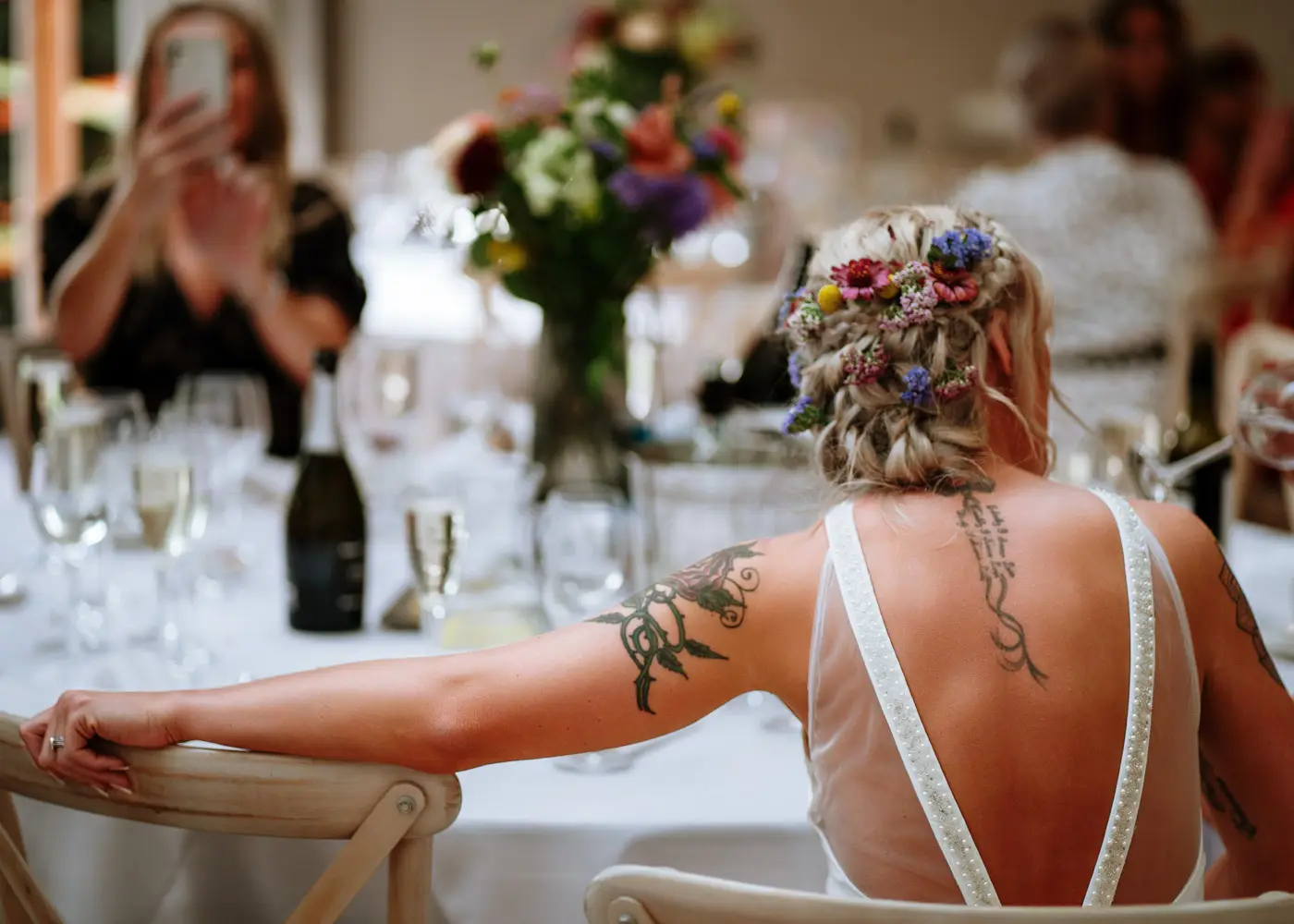 Amy seated with her arm resting on a chair at Doddington Hall, her tattoos visible, a relaxed and intimate portrait by Gary Phillip