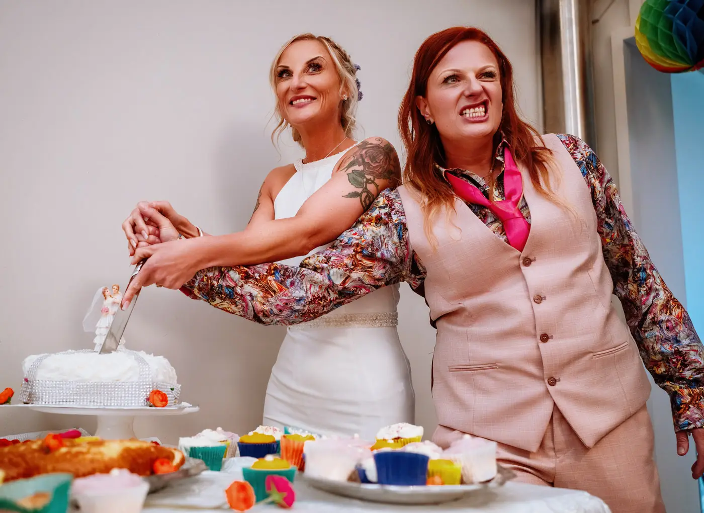 Amy and Abby cutting their wedding cake at Doddington Hall, Lincolnshire with Abby attacking it with great enthusiasm
