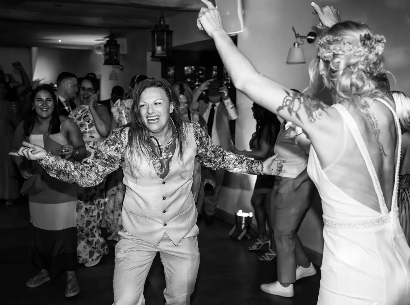 Black and white dancing shot of guests on the dancefloor at Doddington Hall, Lincolnshire during Amy and Abby's wedding evening