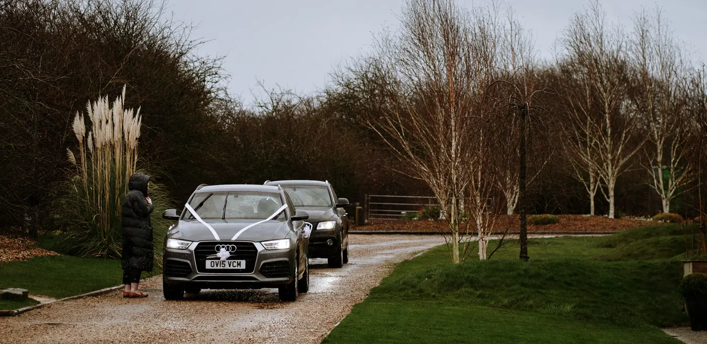Cars arrive with the bridal party at Carriage Hall, Nottinghamshire on a wet February wedding day