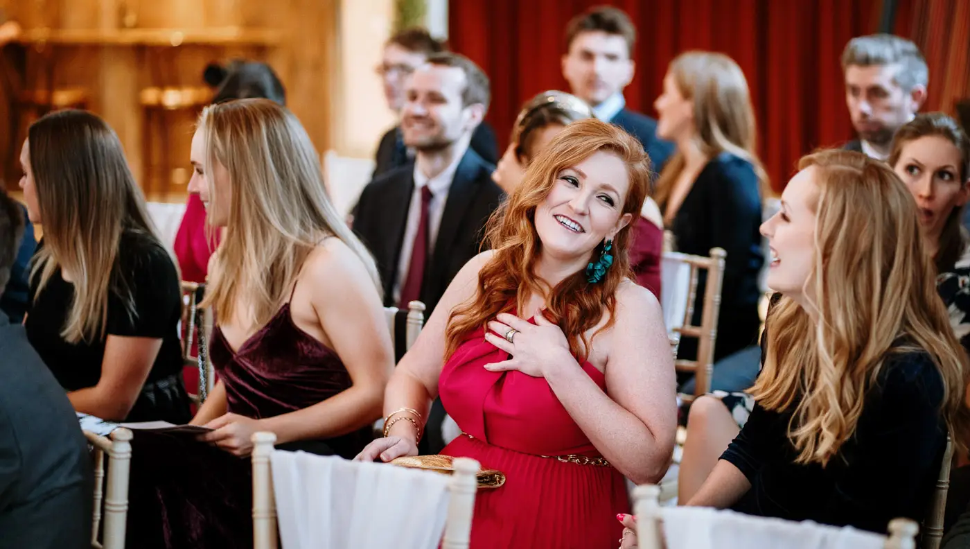Wedding guests chatting while they wait for bride Ellen to arrive at Carriage Hall for her February wedding in Nottinghamshire