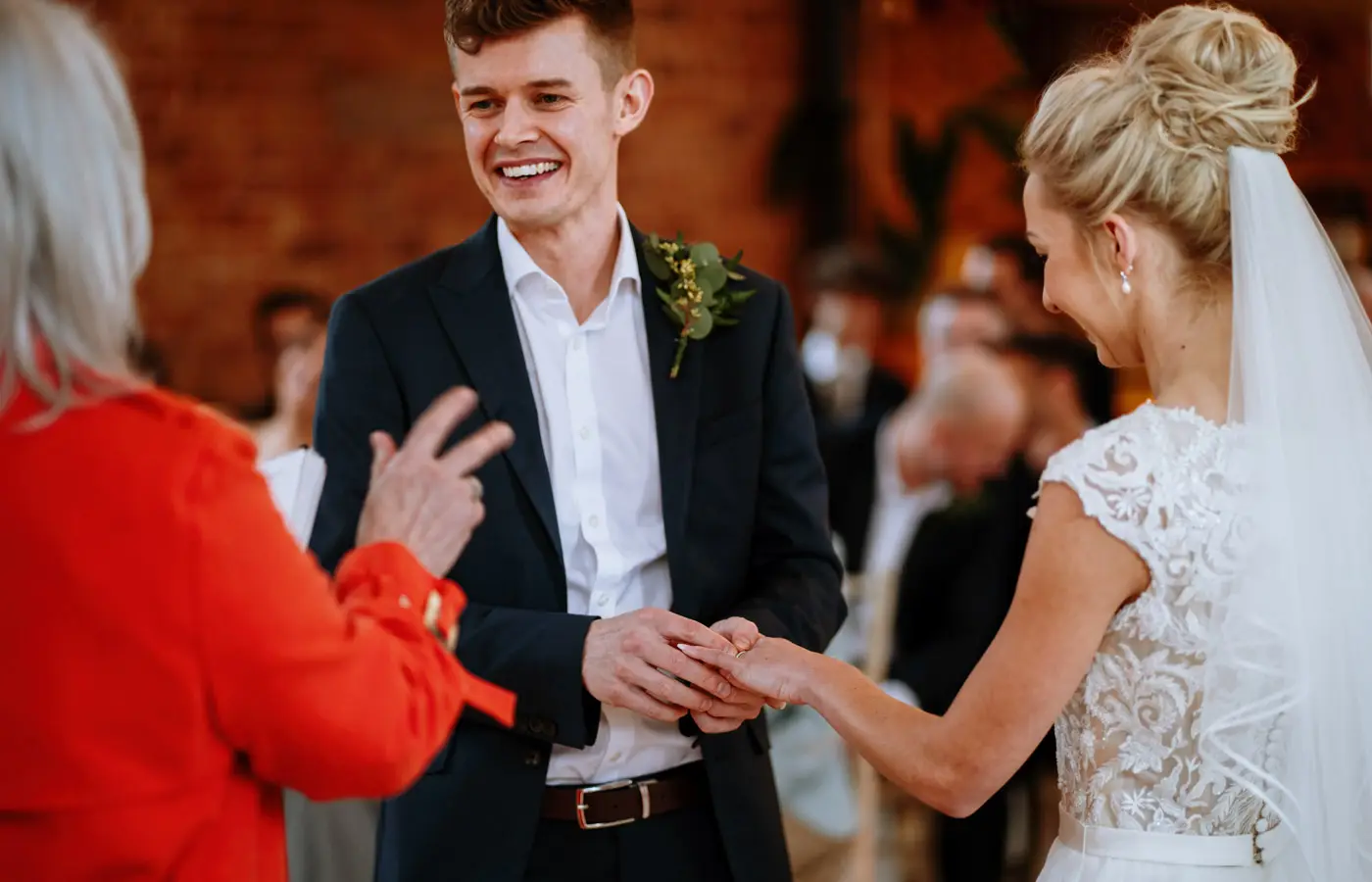 Groom Ben very happy placing the wedding ring on bride Ellen's finger during their ceremony at Carriage Hall, Nottinghamshire