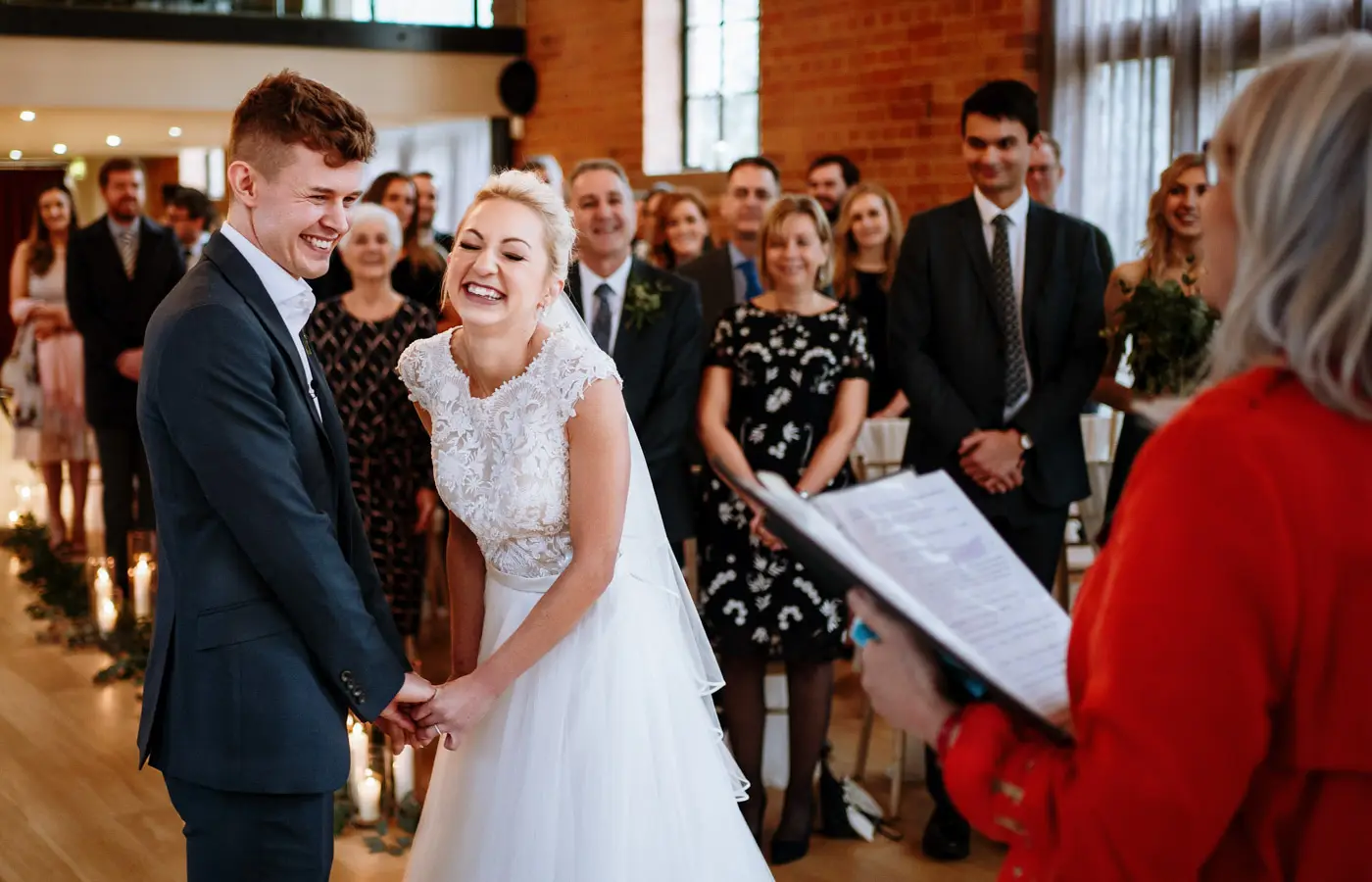 Bride Ellen and groom Ben sharing contagious nervous laughing together during their wedding ceremony at Carriage Hall, Nottinghamshire