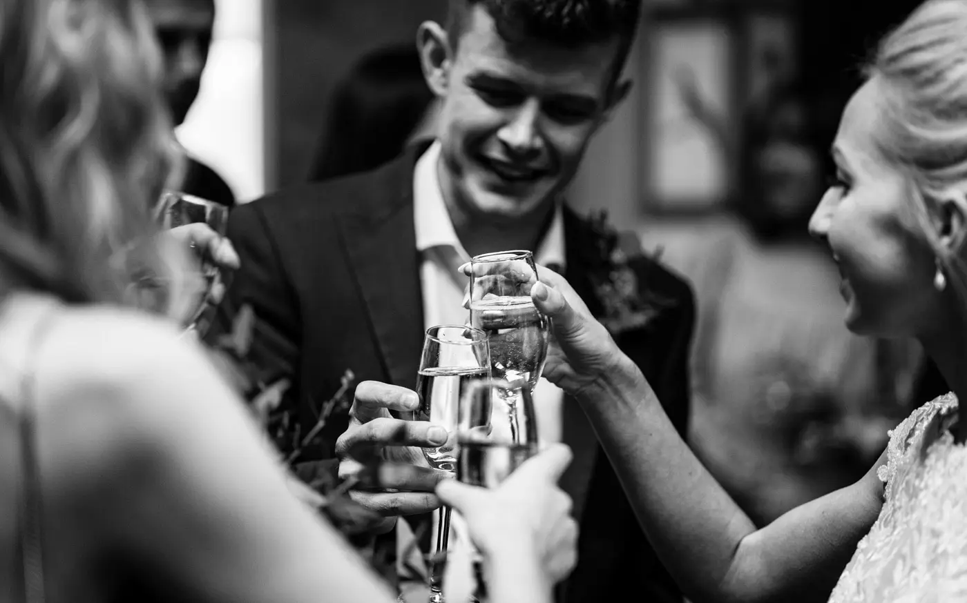 Ellen and Ben chinking champagne glasses together to celebrate their marriage at Carriage Hall, Nottinghamshire