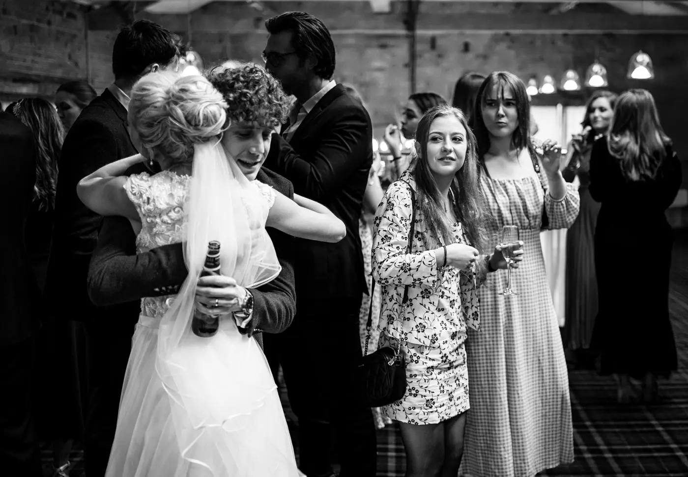 Bride Ellen hugging a guest at Carriage Hall while two other female guests look on with genuine joy and admiration