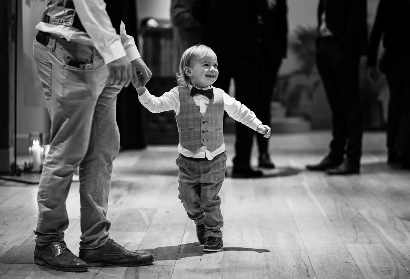 A three year old dancing joyfully with his dad during the drinks reception at Ellen and Ben's wedding at Carriage Hall, Nottinghamshire