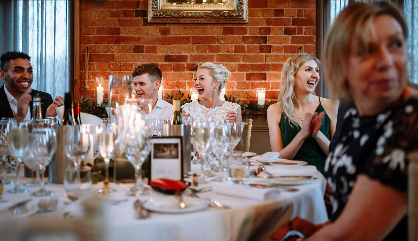 Big laughs around the top table at Carriage Hall during Ellen and Ben's wedding breakfast in Nottinghamshire