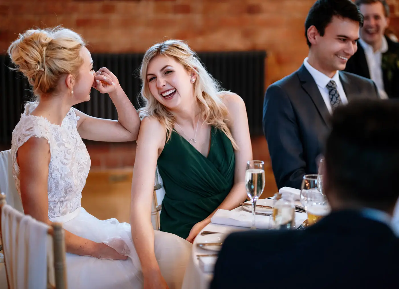 Bride Ellen laughing with her bridesmaid at Carriage Hall, the closeness between them clear in every detail of this documentary wedding photograph
