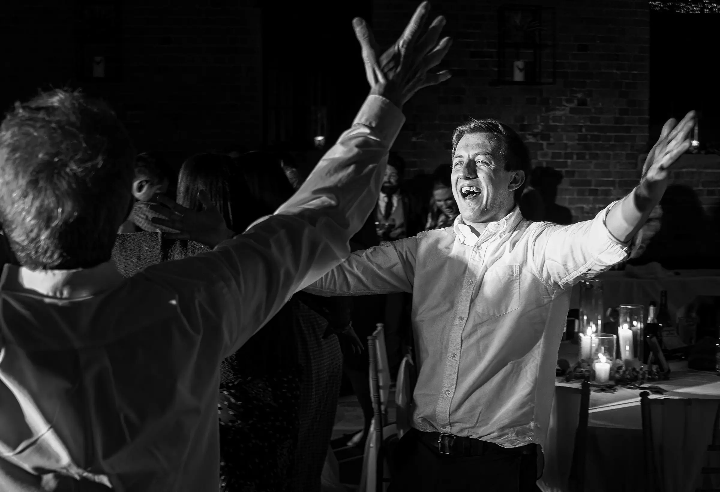 Wedding guests with open arms dancing the night away at Carriage Hall, Nottinghamshire on Ellen and Ben's February wedding night