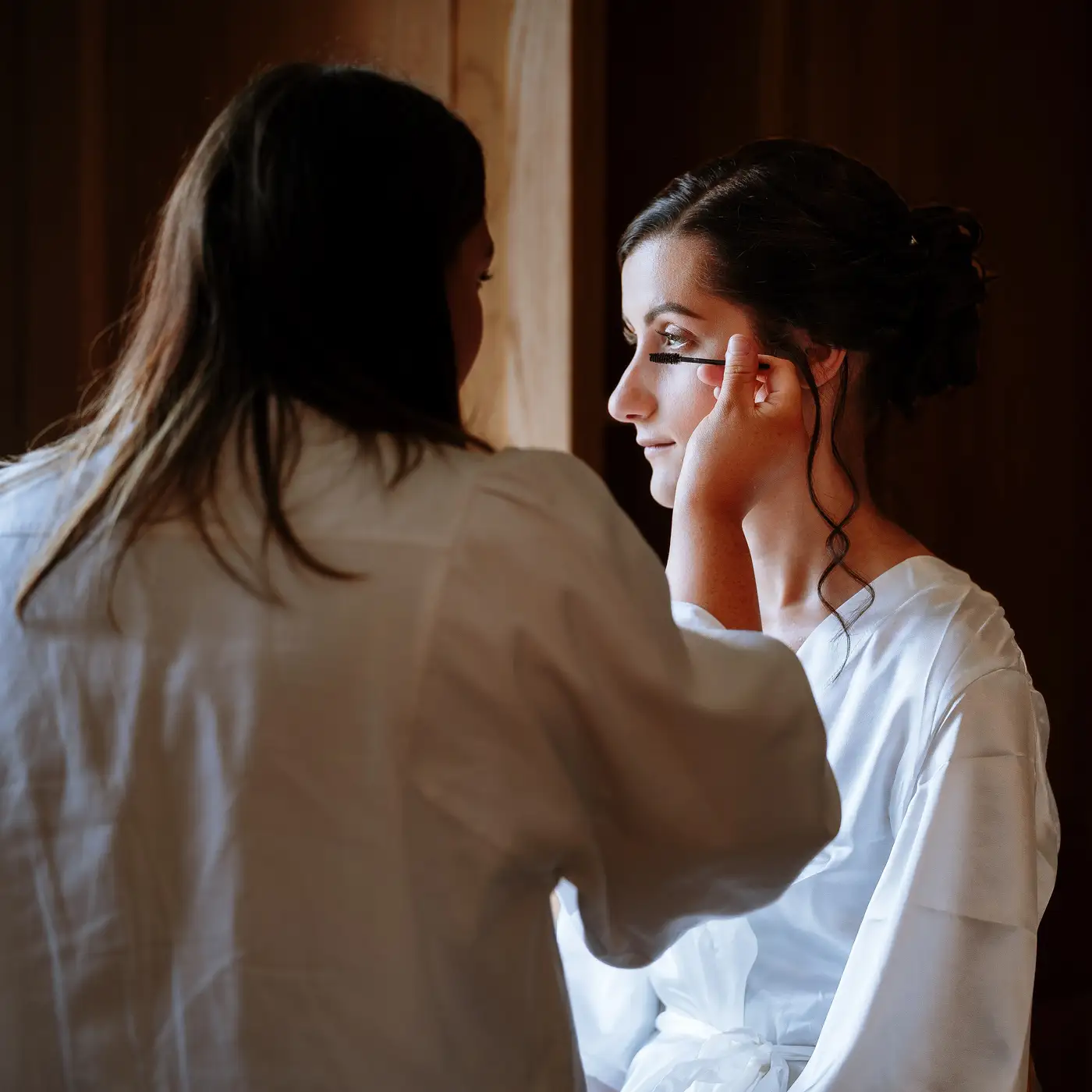 Bride Krissie having her makeup applied in stunning natural light at Swancar Farm, Nottinghamshire, bridal preparation photography by Gary Phillip