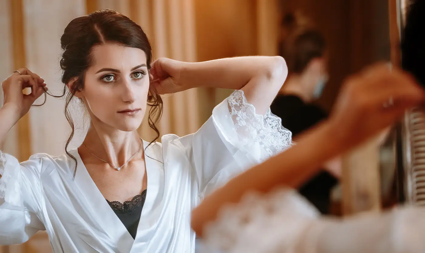 Bride Krissie adjusting her hair in the mirror during wedding morning preparations at Swancar Farm, a quiet self-possessed moment captured by Gary Phillip