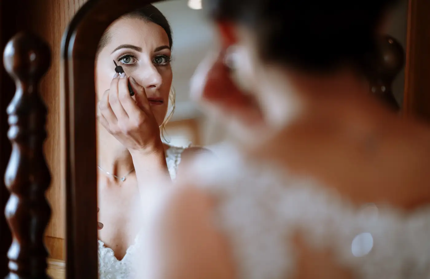 Bride Krissie making last minute touches to her makeup before the ceremony at Swancar Farm, Nottinghamshire, documentary wedding photography by Gary Phillip