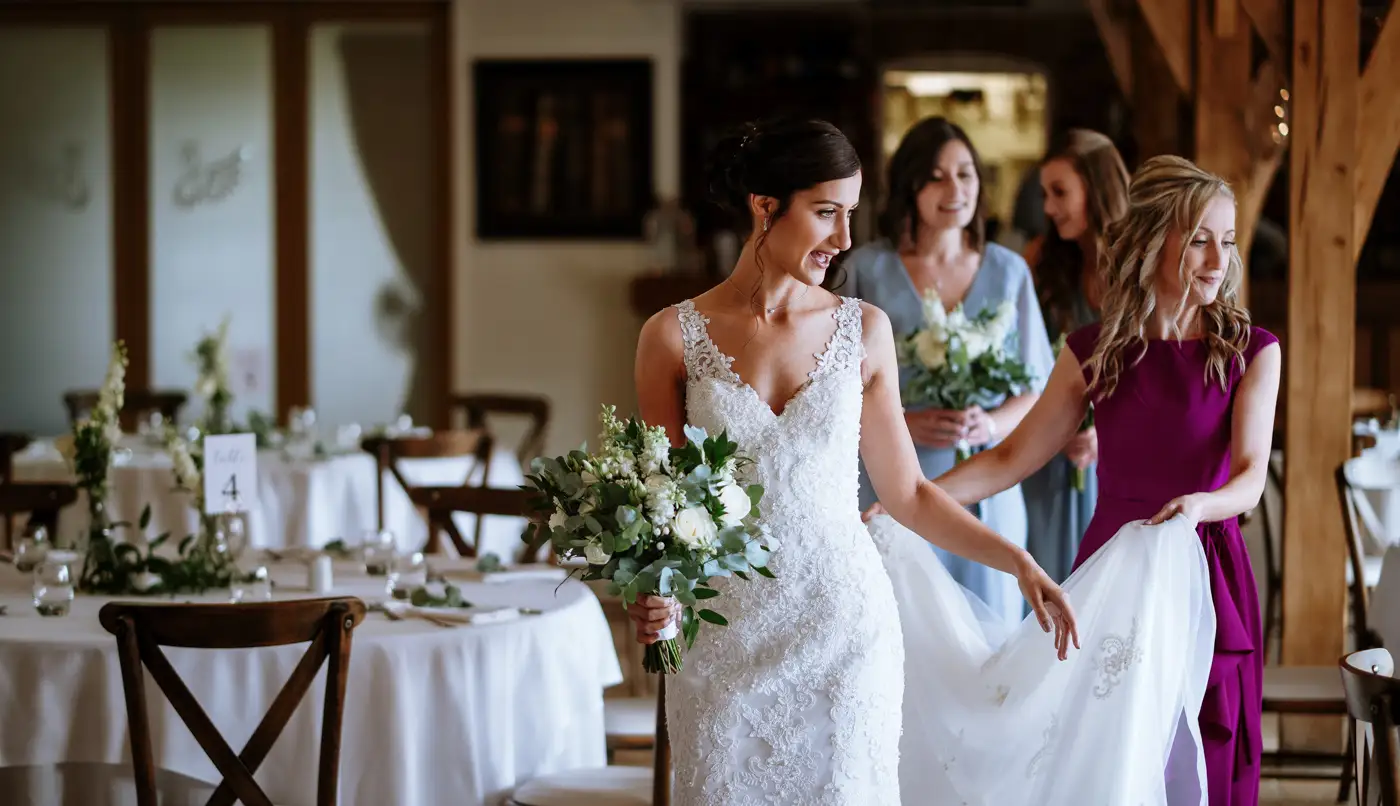 Bride Krissie moving through Swancar Farm's great hall towards her groom with her mother by her side, documentary wedding photography by Gary Phillip, Nottingham