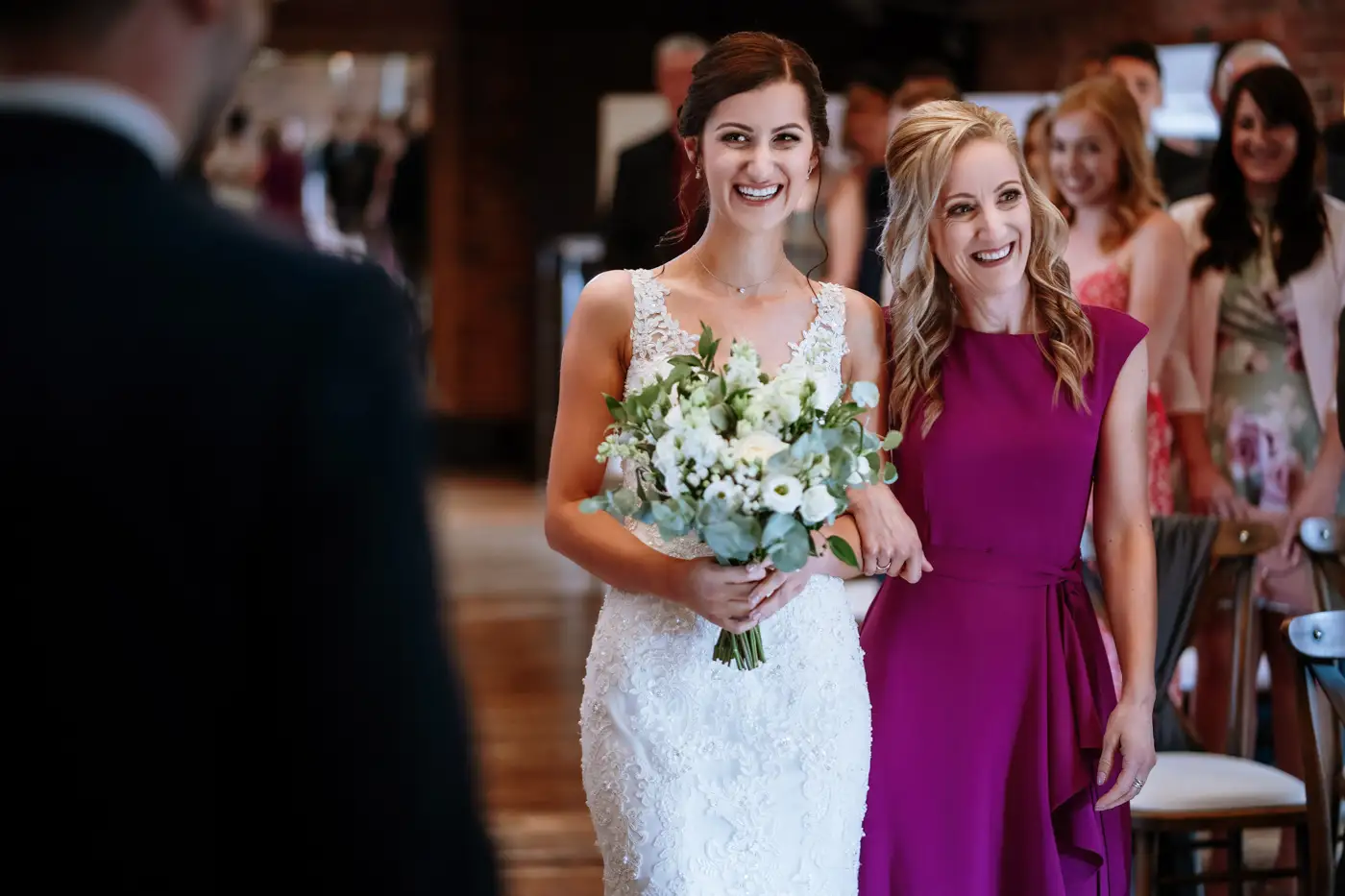 Bride Krissie and her mother sharing a happy moment at the end of the aisle at Swancar Farm, candid wedding photography by Gary Phillip
