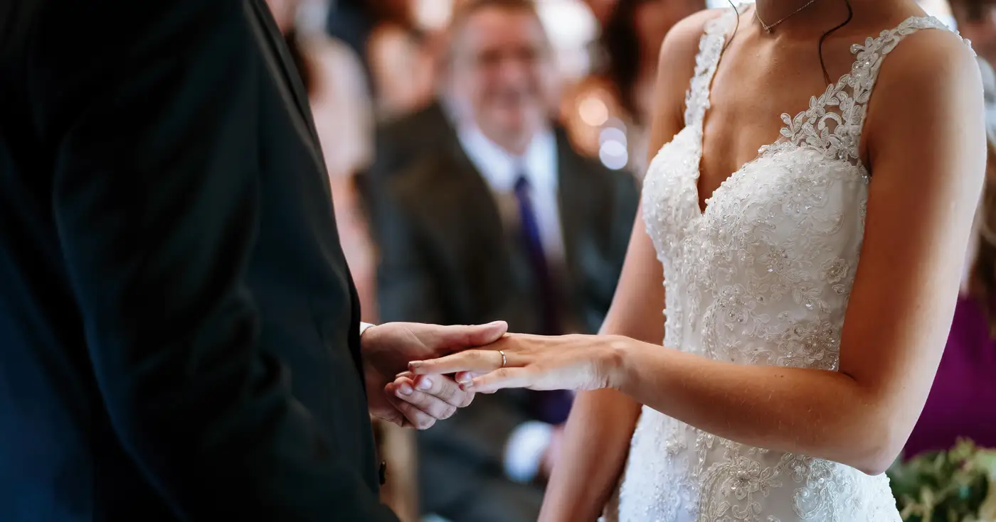 Groom Tom placing the wedding ring on bride Krissie's finger during their ceremony at Swancar Farm, an honest moment captured by Gary Phillip