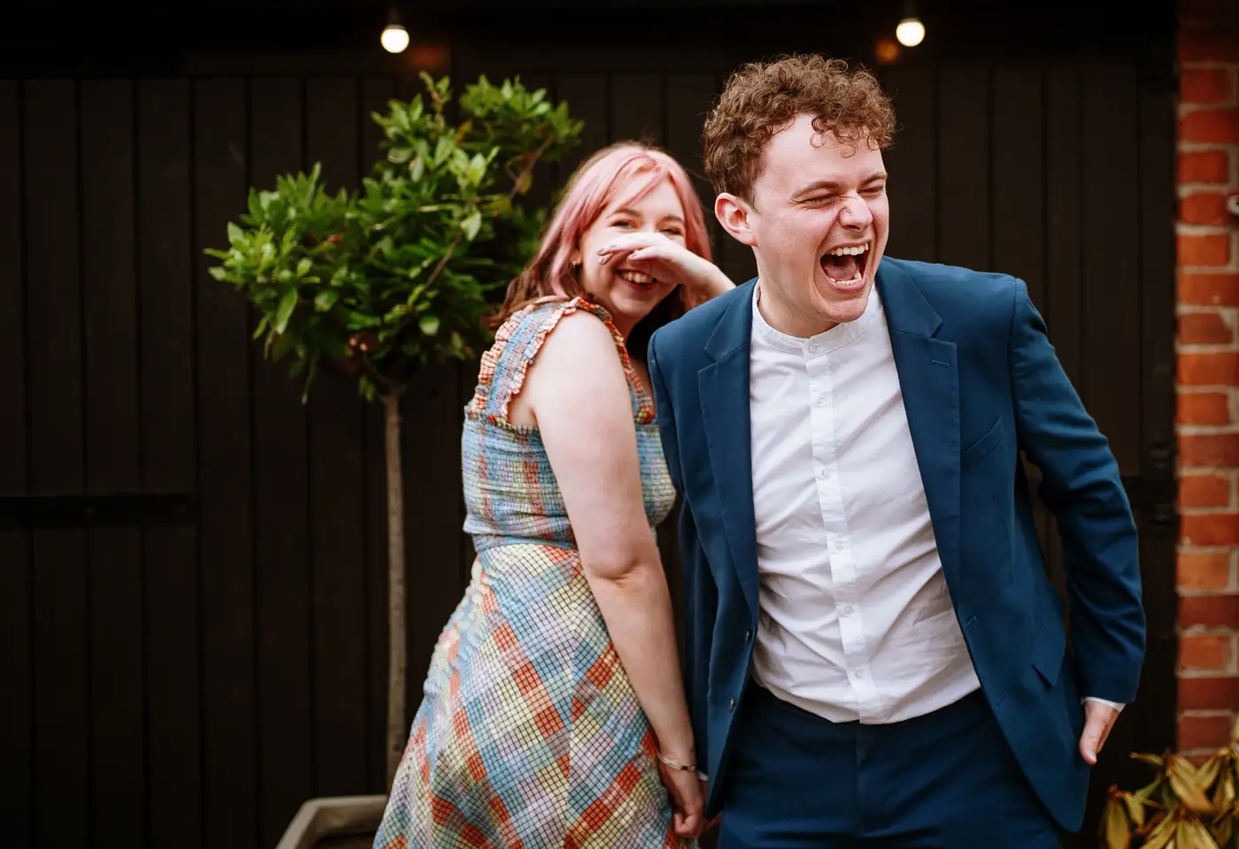 Two wedding guests in hysterics after having their photograph taken at Swancar Farm, Nottinghamshire, candid reception photography by Gary Phillip