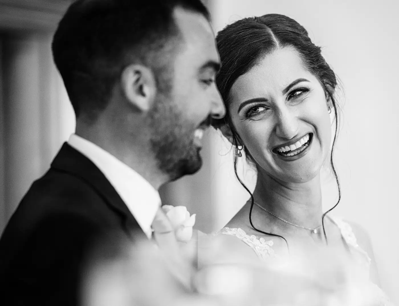 Close up of bride Krissie laughing with groom Tom during the wedding reception at Swancar Farm, Nottinghamshire, honest documentary photography by Gary Phillip