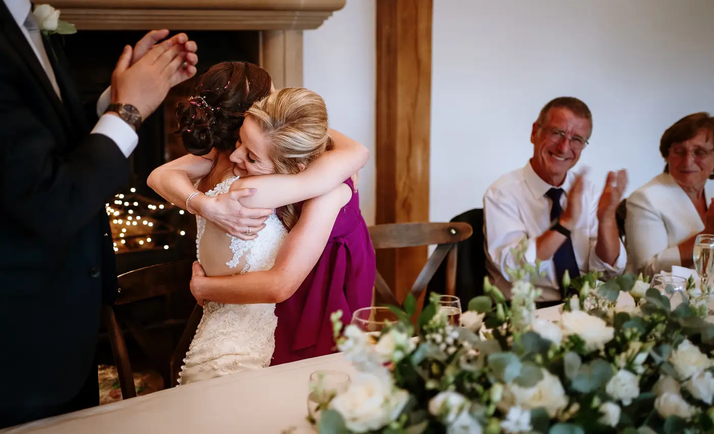 Mother of the bride hugging Krissie after delivering her speech at Swancar Farm, an emotional and tender moment captured by Gary Phillip