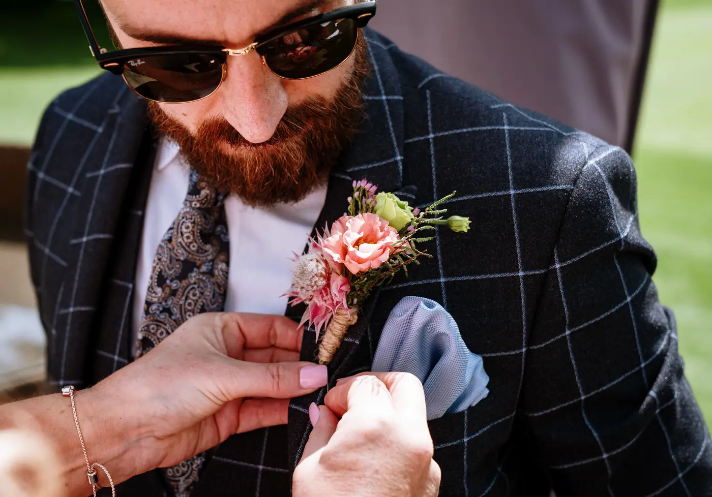 Groom Gavin having his buttonhole fitted before the wedding ceremony at The Walled Garden at Beeston Fields, Nottingham