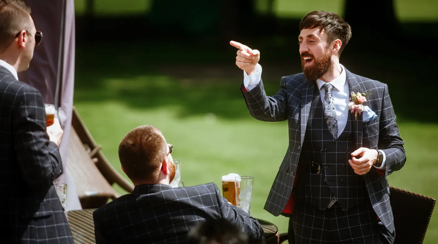 Groom Gavin laughing and pointing at his friends before the wedding ceremony at The Walled Garden at Beeston Fields, Nottingham