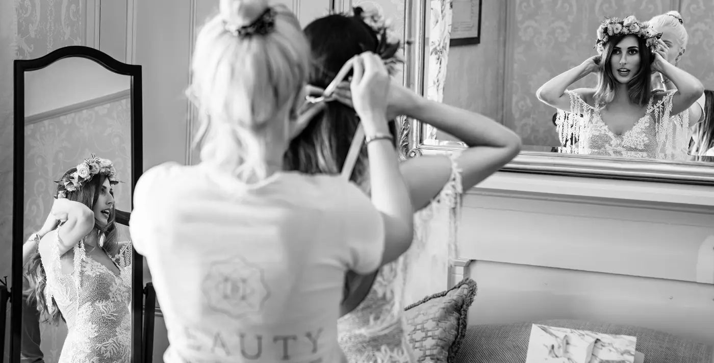 Black and white image of bride Laura fitting her floral crown while reflected in two mirrors simultaneously at Beeston Fields, Nottingham