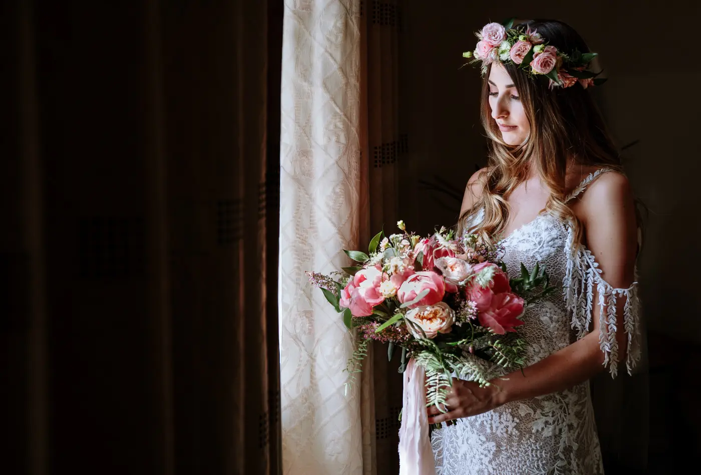 Portrait of bride Laura looking down at her bouquet in beautiful natural window light at The Walled Garden at Beeston Fields, Nottingham