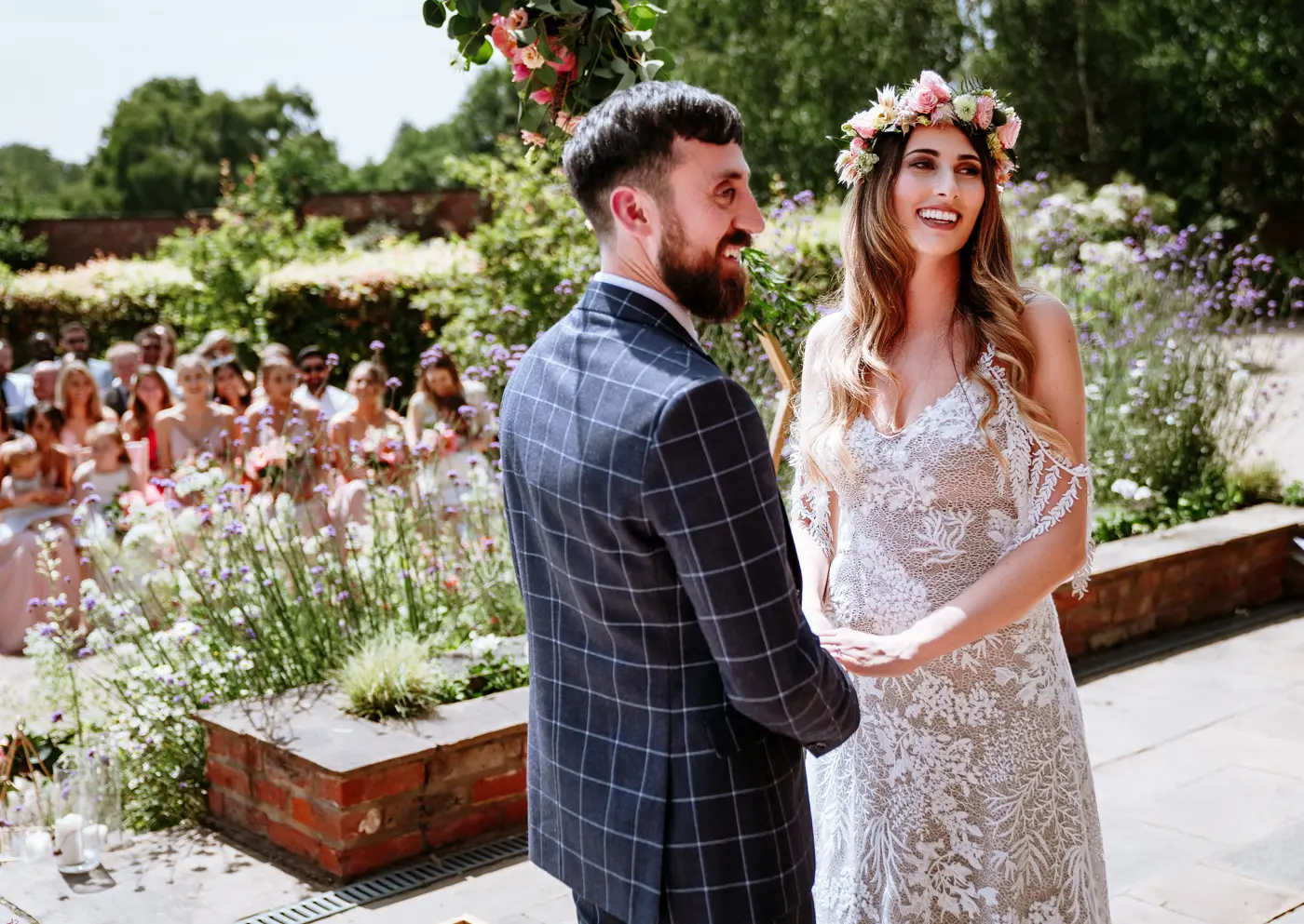 Bride Laura and groom Gavin laughing together during their outdoor wedding ceremony at The Walled Garden at Beeston Fields, Nottingham