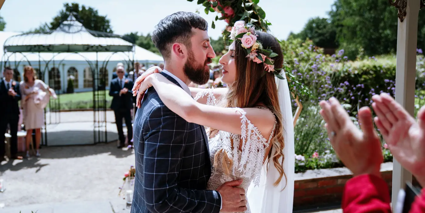 First kiss. Laura and Gavin share their first kiss as a married couple at The Walled Garden at Beeston Fields, Nottingham, photographed by Gary Phillip