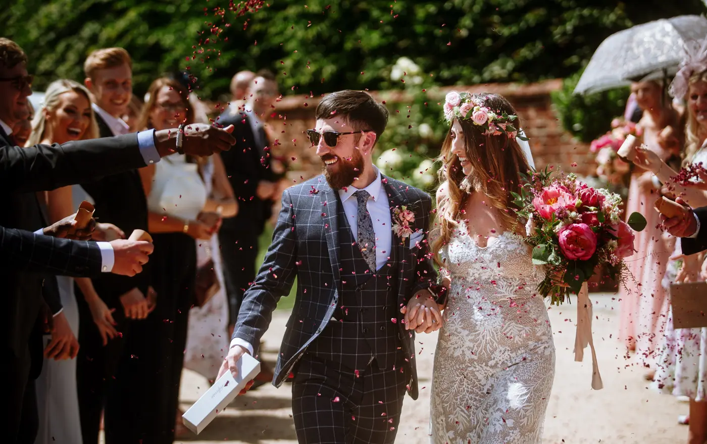 Laura and Gavin running the confetti gauntlet with huge smiles after their wedding ceremony at Beeston Fields, Nottingham
