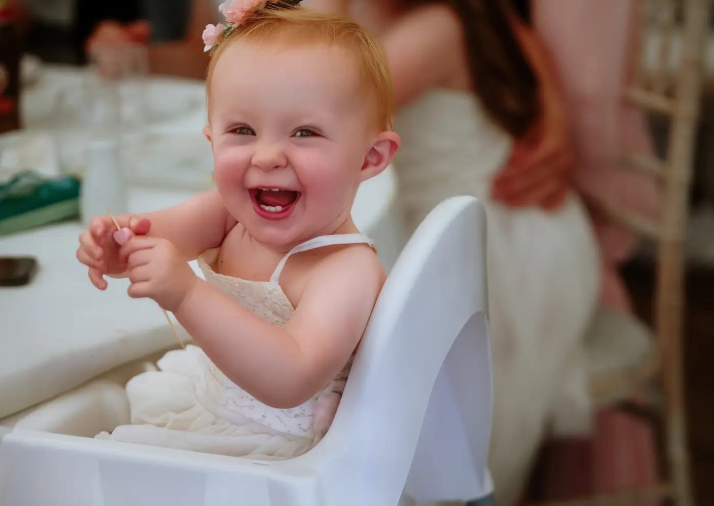 A young baby laughing and looking directly into the camera at The Walled Garden at Beeston Fields, Nottingham, a joyful candid moment by Gary Phillip