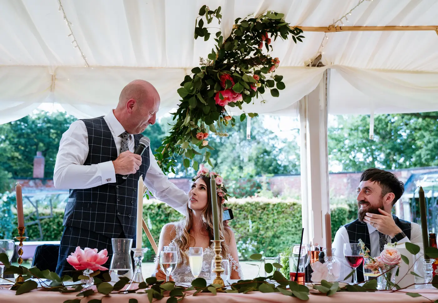 Father of the bride sharing a quiet moment with daughter Laura while groom Gavin looks on with a wry smile at The Walled Garden at Beeston Fields