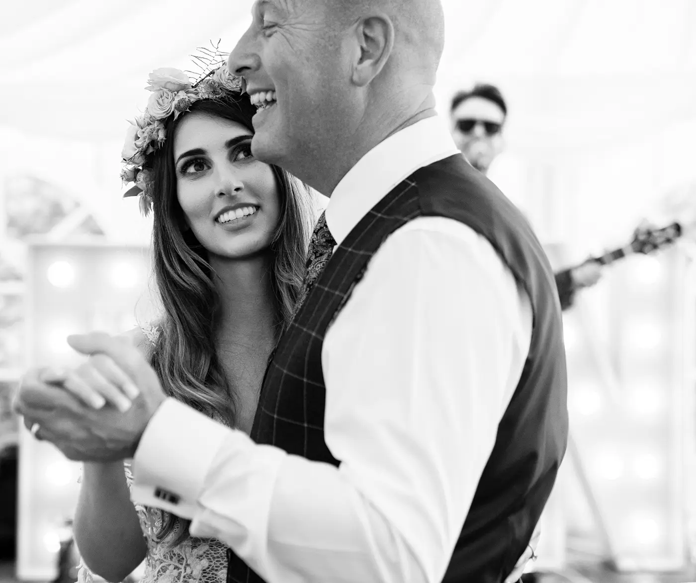 Bride Laura looking up in awe at her father as he sings along to the band during their father daughter dance at Beeston Fields, Nottingham