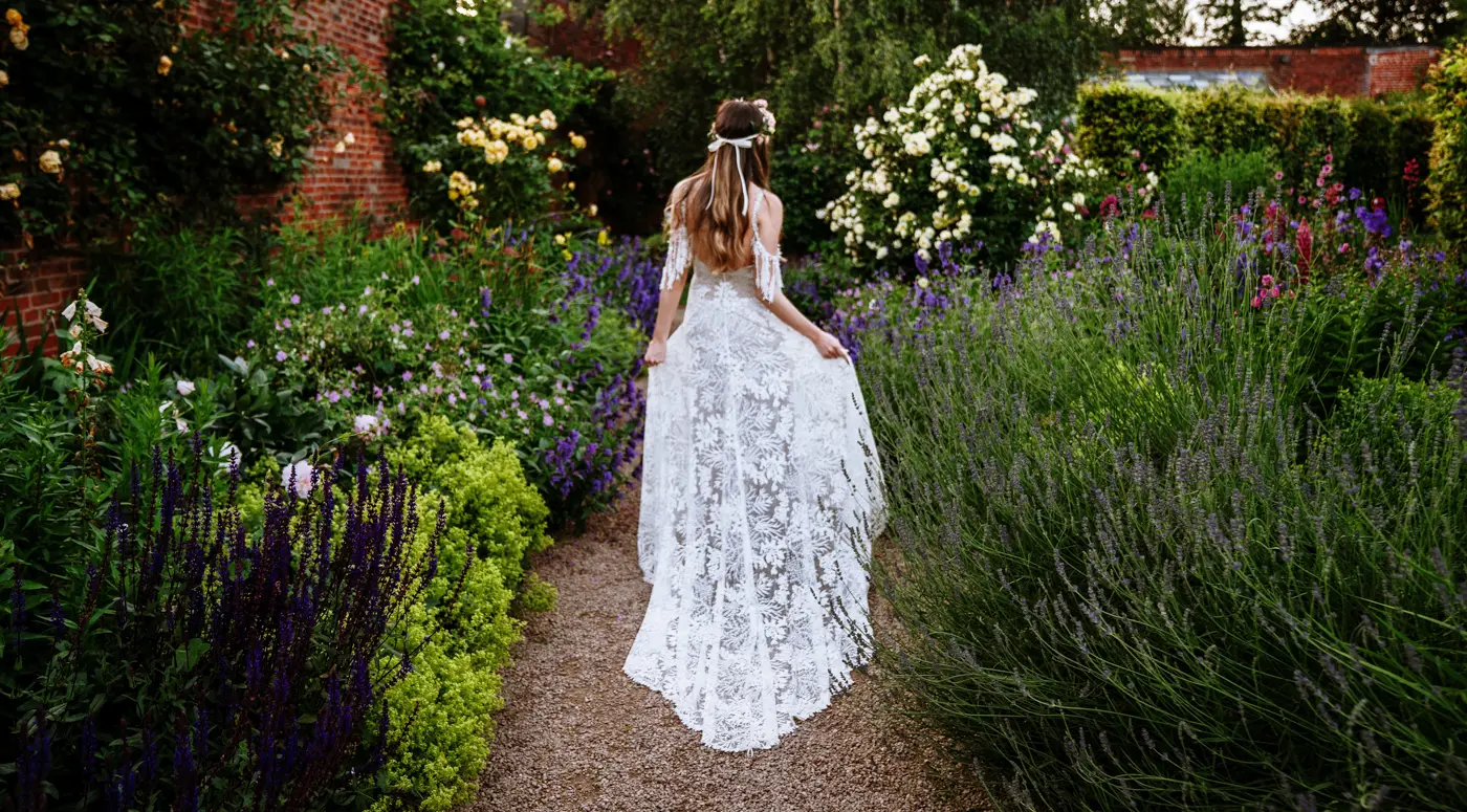 Bride Laura making her way through the colourful walled garden at Beeston Fields, Nottingham, a beautiful natural moment captured by Gary Phillip